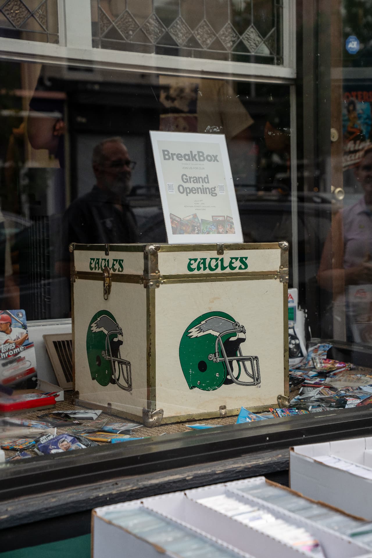 TheBreakBox card shop window in Manayunk with a vintage Eagles trunk and Grand Opening sign