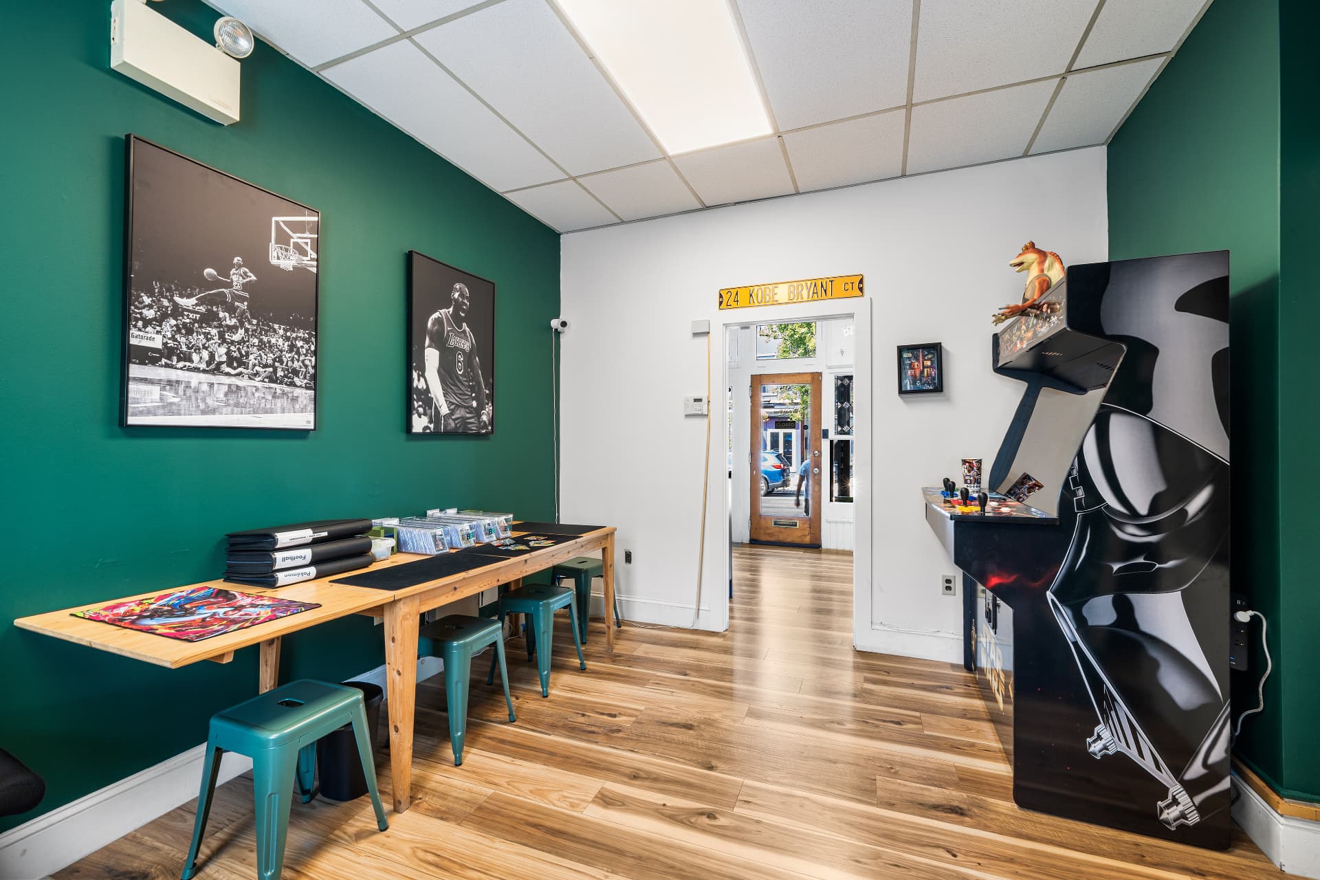 The trade table inside TheBreakBox card shop with stools, card binders and framed prints
