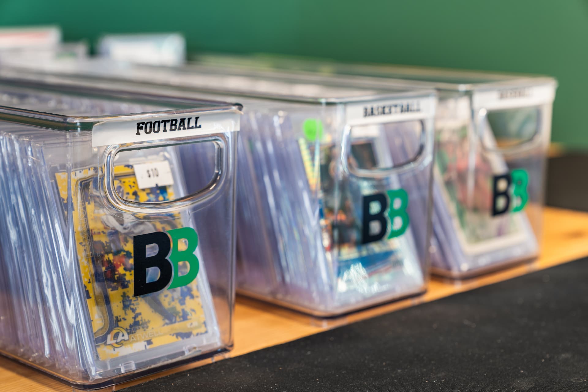Bins of football, basketball and Pokemon card singles sleeved and priced at TheBreakBox